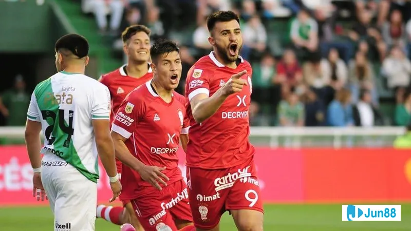 Cầu thủ Huracan vượt qua cầu thủ Banfield bằng kỹ thuật đi bóng tinh tế trên sân cỏ